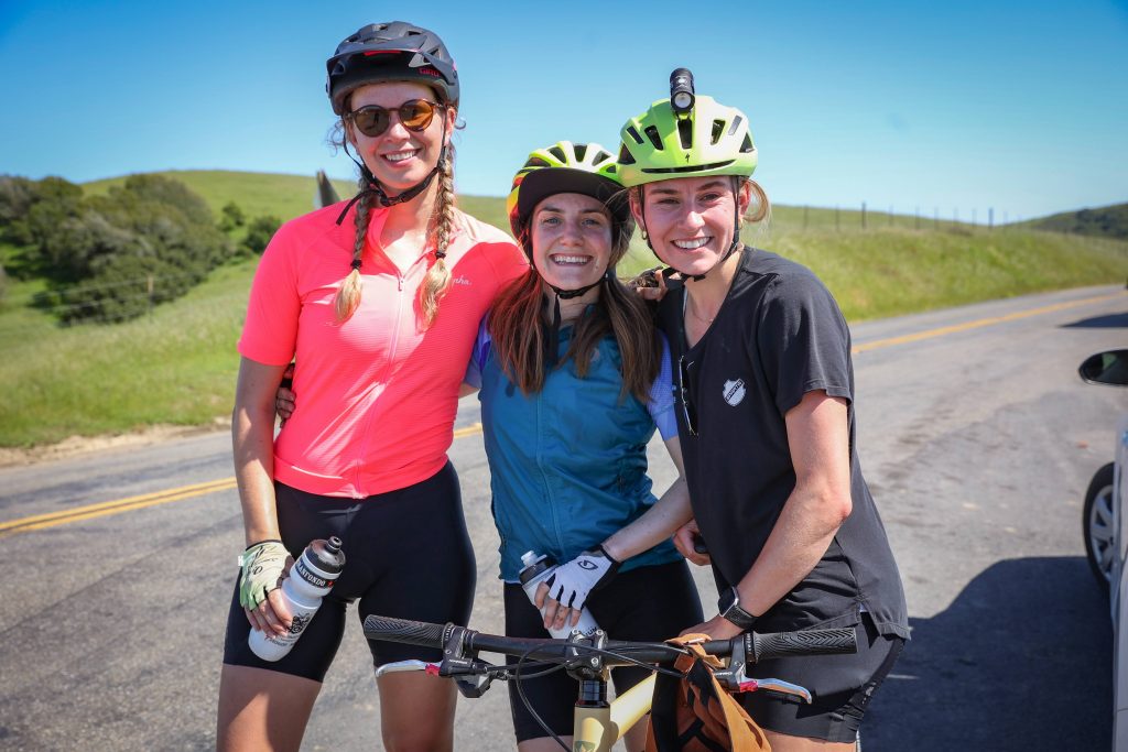 Three women in cycling gear pose